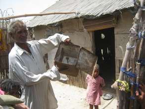 Mr. Juma showing empty box of flour / Atta