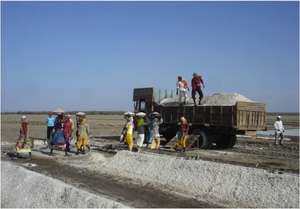 Women carry salt to middle men