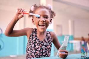 Child in Chuspa with donated tooth-brushing kit.