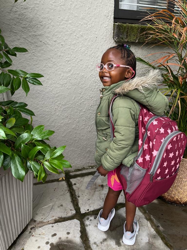 A little girl with the biggest school bag ever!