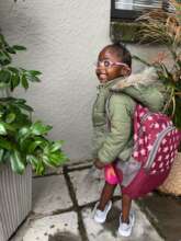 A little girl with the biggest school bag ever!