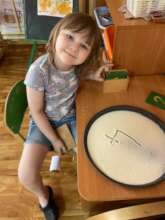 Young girl having written the number 4 in sand