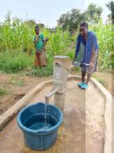 Girl drawing water from the handpump