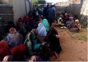 Women, children, and men gather in a narrow space