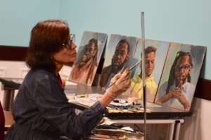 Artist Cindy Catotti with her portraits