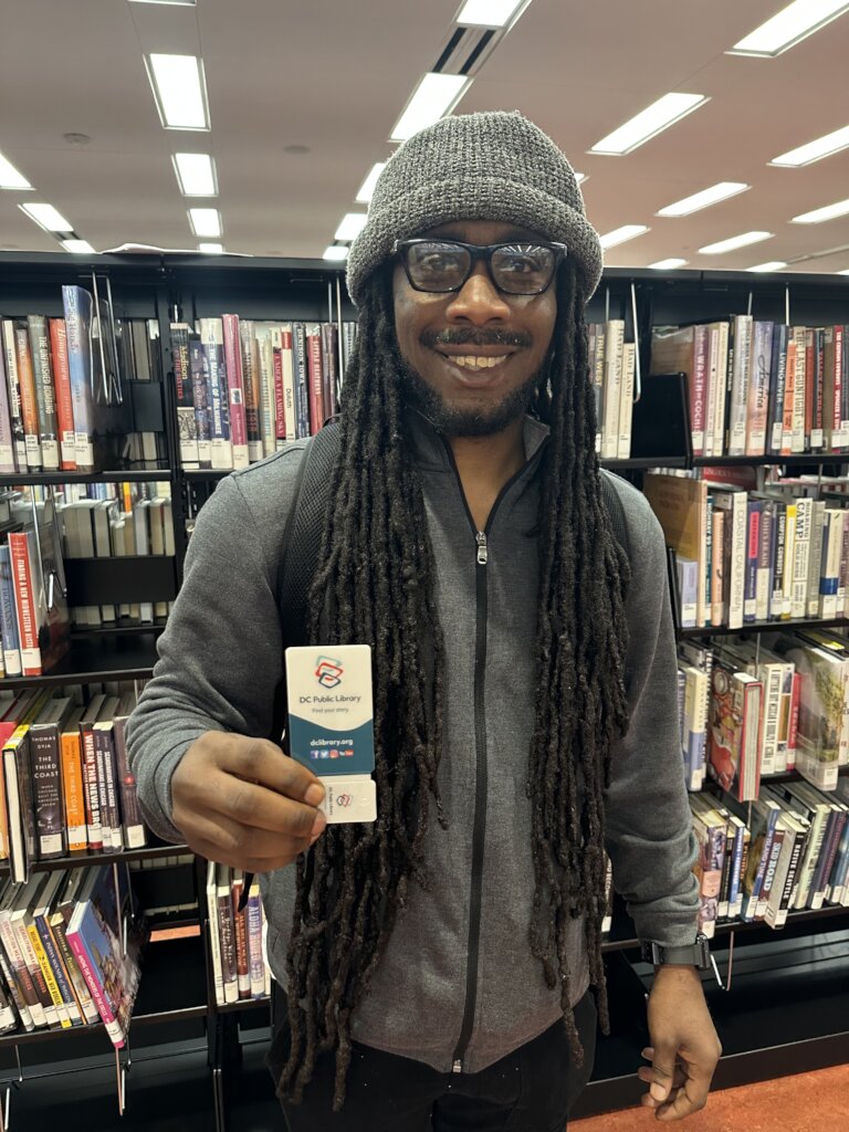 FM member Anthony holding library card