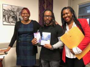 FM Apprentice Shannon is gifted a book by FM Staff