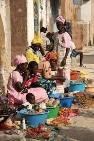 A woman selling with her baby beside her at makola