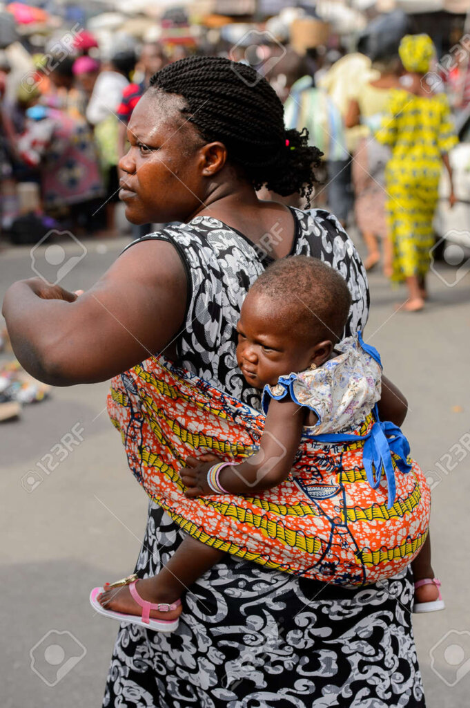 A market woman with her baby in the sun