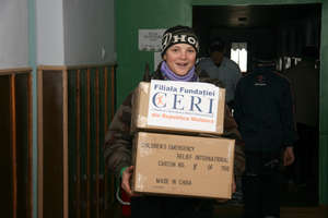 Children help carry boxes with boots