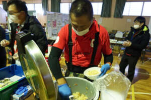 AAR Director serving rice at an evacuation center