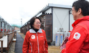 Talking in front of a temporary housing complex