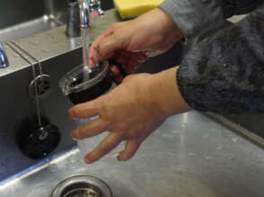 Woman washing dishes with water from the well