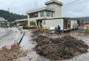 Mud shoveling at a flooded temporary housing