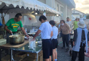 AAR Director Kato (left) handing out food