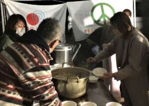 Staff cooking in an outdoor tent.