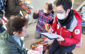 AAR staff listens to a woman at a shelter in Noto