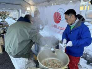 staff and volunteers cooking for a hot meal