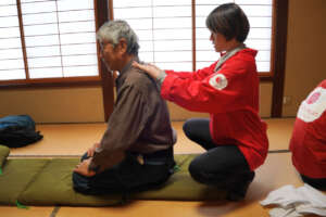A physical therapist massages a victim at Wajima