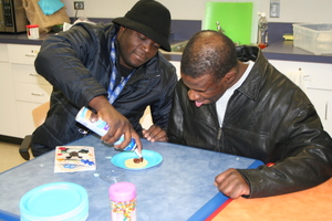 Staff assist Joe in making a sugar cookie.