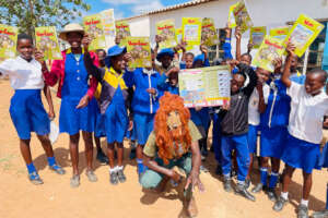 Children with teacher and Lion comics in Zimbabwe