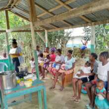 Children and their mothers attend a cooking class