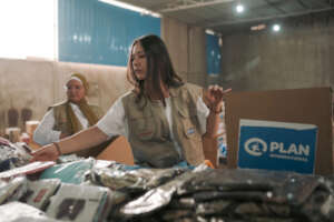 Workers fill boxes with menstrual health kits