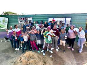 Maria and children in front of container