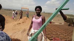 Worker and bricks, sieve in background