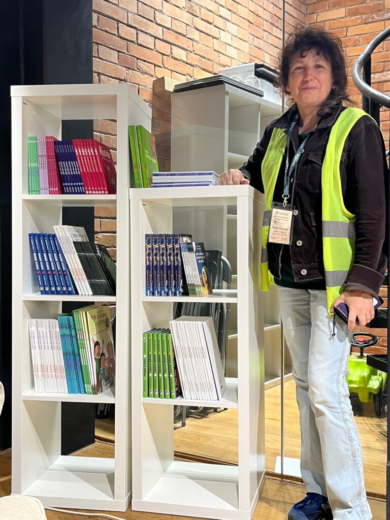 Volunteer proud of a bookshelf for refugees