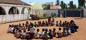 Children at the school, greenhouse in background