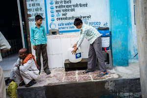 Two boys filling up their iJal with safe water