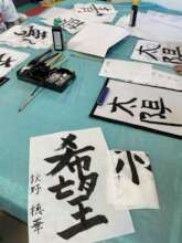 Volunteers from Japan lead a calligraphy session