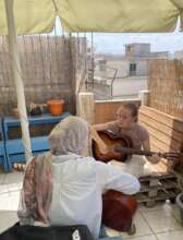 Vivi teaches guitar during Refugee Week Greece
