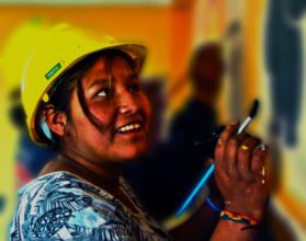 A woman builder painting a mural.