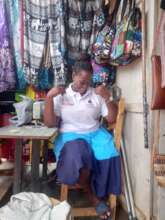 Sharon, supports herself as she makes dignity pads