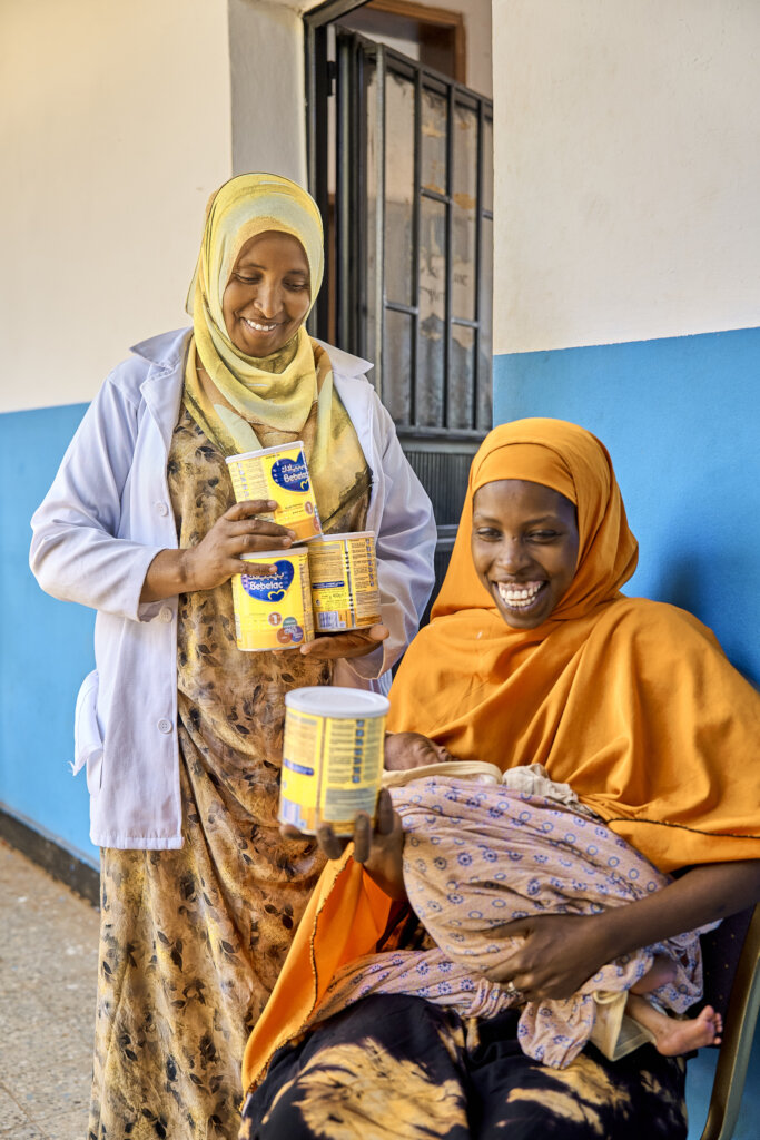 Abdurazak and her mother receiving milk powder.