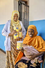 Abdurazak and her mother receiving milk powder.