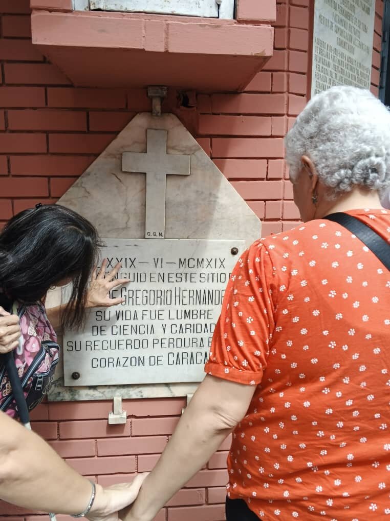 2 deafblind people touching a plaque on the corn