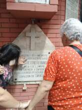 2 deafblind people touching a plaque on the corn