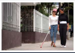Outside with cane and interpreter guide