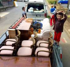Happy kid helping pack his family's furniture
