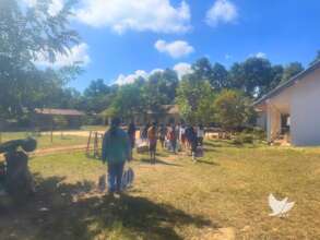 Lao girls carry back school supplies given by AAT