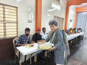 Founder Trustee serving dessert to the ACT Fathers