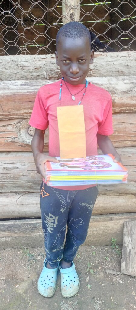 Elijah Primary Three receives his fees and books