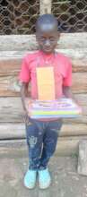 Elijah Primary Three receives his fees and books