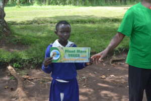 Girl Holds a card reading environmental conservati