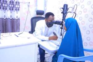 "Dr. Hamze performing an eye examination a student