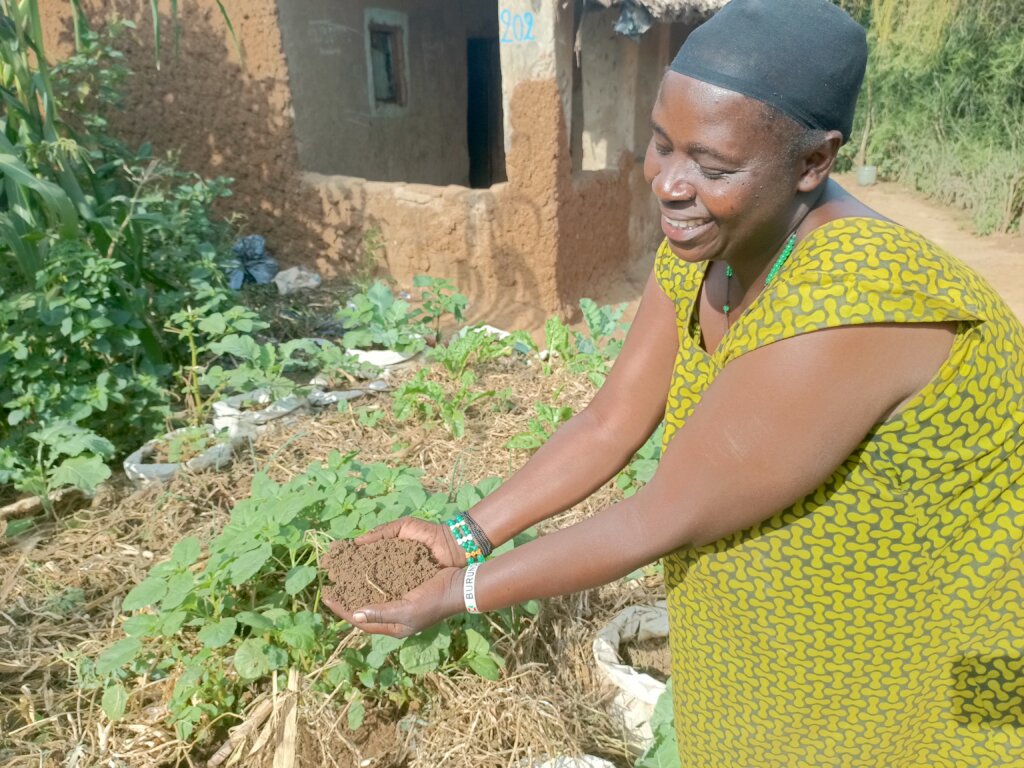 Maria showing her soil from the sack garden