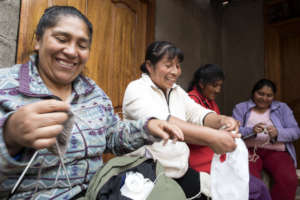 Rosa, Matilda, Demi and Yudi laugh while knitting.